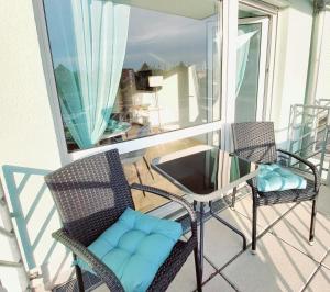 - Balcón con 2 sillas y mesa de cristal en Moderne Wohnung mit Vollausstattung in ruhiger Lage, W-LAN, en Großröhrsdorf