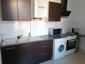 a kitchen with a washing machine and a microwave at Cœur de Loire in Blois +12 photos