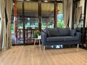 a living room with a blue couch and a table at Good View House - Koh Yao Noi in Ko Yao Noi
