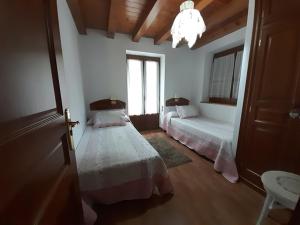 a bedroom with two beds and a chandelier at Cap De La Vila in Vielha