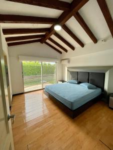 a bedroom with a bed and a large window at comfortable country house in Pereira
