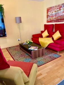 a living room with a red couch and a table at Luxurious city apartment incl garage and terrace in Vienna