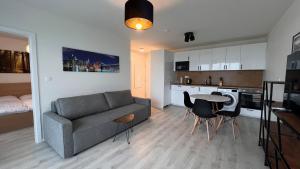 2 room Apartment with terrace, new building, 8BJ في براتيسلافا: غرفة معيشة مع أريكة وطاولة ومطبخ