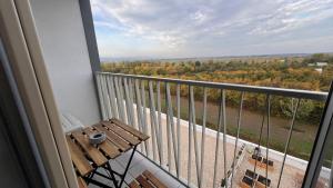 een balkon met een houten bank en uitzicht op de bomen bij 2 room Apartment with terrace, new building, 8BJ in Bratislava