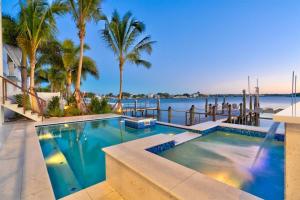a swimming pool with a view of the water at Bayside Paradise Mansion in Clearwater Beach