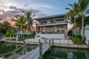 a house on the water with palm trees at Bayside Paradise Mansion in Clearwater Beach