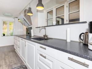 a kitchen with white cabinets and a black counter top at Holiday home Thisted LVII in Thisted