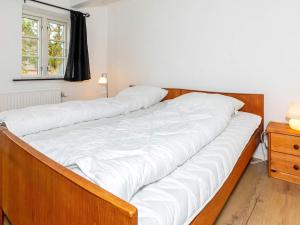 Holiday home Thisted LVII في ثيستد: سرير كبير مع شراشف بيضاء في غرفة النوم