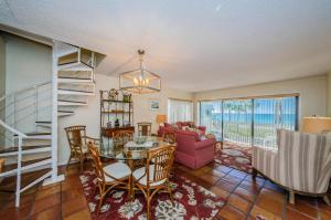a living room with a staircase and a table and chairs at Beachfront Aldea 6 in Clearwater Beach