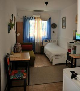 a bedroom with a bed and a couch and a table at Studio5, sa parkingom, centar Obrenovca in Obrenovac