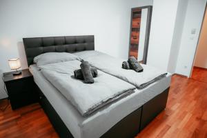 een slaapkamer met een bed met een zwart hoofdeinde bij Vienna Shopping Center 8 Appartment in Wenen +42 foto's