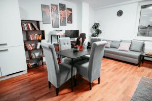 een woonkamer met een tafel, stoelen en een bank bij Vienna Shopping Center 8 Appartment in Wenen