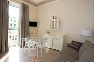 un soggiorno con divano e tavolo in vetro di Hotel Dei Fiori Restaurant - Meeting & Spa ad Alassio