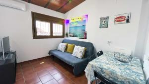 ein Wohnzimmer mit einem Sofa und einem Tisch in der Unterkunft Apartamento con Terraza en la Playa con Piscina in La Cala del Moral