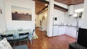 a kitchen and dining room with a table in a room at Apartamento con Terraza en la Playa con Piscina in Cala del Moral