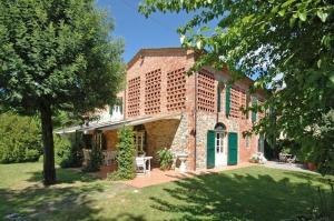 un edificio de ladrillo con una puerta verde en un patio en Villa Fontine by PosarelliVillas, en Orentano