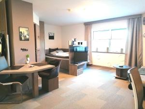 een woonkamer met een tafel en een kamer met een bed bij Business Apartments in Hohenems