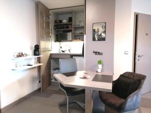 een kleine keuken met een tafel en 2 stoelen bij Business Apartments in Hohenems