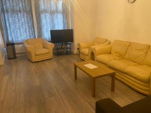 a living room with two couches and a tv at Homely 3 Bedroom Ground Floor Flat in London