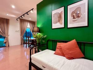 ein grünes Zimmer mit einem Bett und einer grünen Wand in der Unterkunft (New) Beachside Antique Villa@14 pax in George Town
