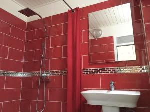 a red bathroom with a sink and a mirror at Appart Clim Wifi 700m de la Plage in Saïdia