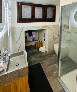 een badkamer met een douche, een wastafel en een toilet bij Canzo Centro in Canzo