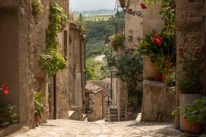 eine Gasse in einer Altstadt mit Blumen in der Unterkunft Casa Cuoco in Civita Campomarano