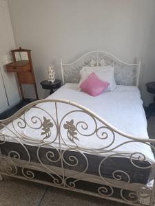 ein Bett mit einem rosa Kissen darüber in der Unterkunft Appartement familial in Mohammedia