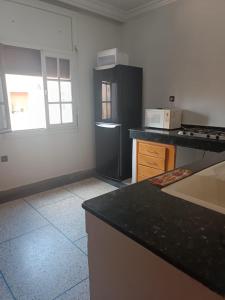 eine Küche mit einem schwarzen Kühlschrank und einer Arbeitsplatte in der Unterkunft Appartement familial in Mohammedia
