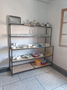 ein Regal mit Geschirr und anderen Artikeln darauf in der Unterkunft Appartement familial in Mohammedia