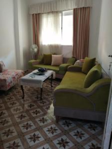 un soggiorno con divano verde e tavolo di Dar manena a Al-Qayrawan