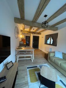ein Wohnzimmer mit einem Sofa und einem Tisch in der Unterkunft La Vitrine in Gertwiller
