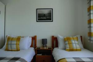 a room with two beds and a picture on the wall at Black Sheep Bunkhouse in Fort William
