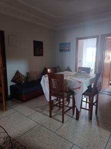 ein Esszimmer mit einem Tisch, Stühlen und einem Sofa in der Unterkunft Appartement familial in Mohammedia