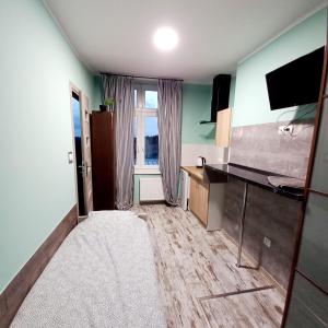 Kleines Zimmer mit einer Küche und einem TV. in der Unterkunft CENTRUM NOCLEGI WĄGROWIEC in Wągrowiec