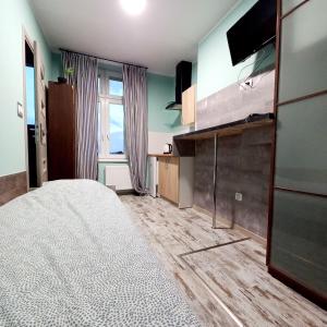 1 dormitorio con 1 cama y TV en CENTRUM NOCLEGI WĄGROWIEC, en Wągrowiec