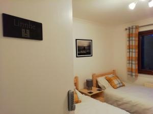 Habitación pequeña con 2 camas y ventana en Black Sheep Bunkhouse, en Fort William