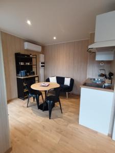 a kitchen and dining room with a table and chairs at La Cabane de Camille 