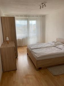 una camera con un letto e una grande finestra di 2 rooms apartment with balcony a Zvolen