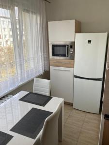 uma cozinha com um frigorífico branco e uma mesa em 2 rooms apartment with balcony em Zvolen