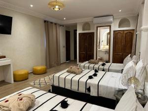 a hotel room with two beds and a television at Riad Medina Art & Suites in Marrakech