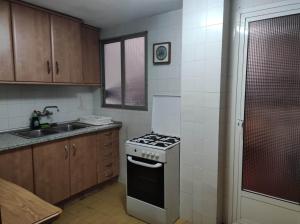 a small kitchen with a stove and a sink at Habitacion in Alicante