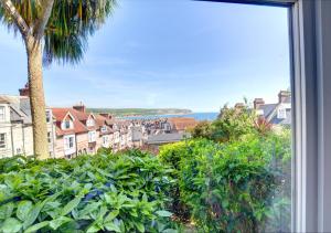 a window with a view of a city and the ocean at Marys Corner in Swanage