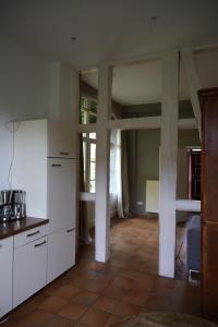 a large kitchen with white cabinets and a floor at Altes Schulhaus in der Lüneburger Heide in Lachendorf