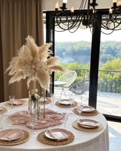 einen Tisch mit einem weißen Tischtuch und Blumen darauf in der Unterkunft Zora’s Home in Irig