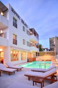 a hotel with a swimming pool in front of a building at Erato Hotel in Agia Marina Aegina