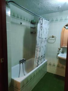 a bath tub with a shower curtain in a bathroom at Habitacion in Alicante