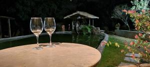 dos copas de vino sentadas sobre una mesa en Sítio Roda d'Água en Lagoa Santa