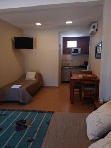a room with a bed and a desk and a kitchen at Temporario Necochea 2 corrientes in Corrientes