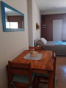 a room with a wooden table with chairs and a bed at Temporario Necochea 2 corrientes in Corrientes
